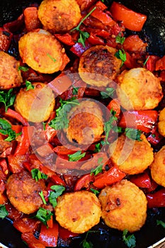 Rice balls with vegetables. Fried rice balls with stewed red pepper, onions and tomatoes in a pan. Homemade veggie balls