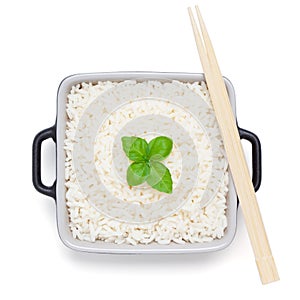 Rice with basil in ceramic bowl with wooden chopsticks