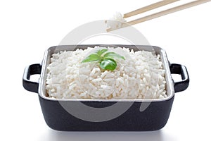 Rice with basil eaten from ceramic bowl with wooden chopsticks