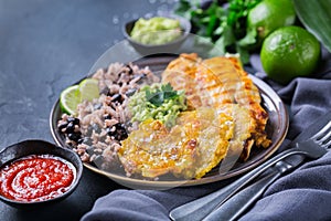 Rice with black beans, fried chicken breast and tostones, plantains