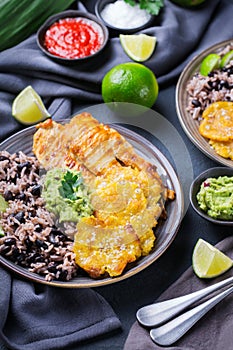 Rice with black beans, fried chicken breast and tostones, plantains photo