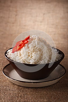 Rice bowl with fresh chillies rustic background