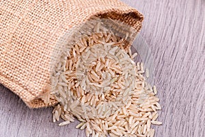 Rice brown spilling from sack on the table