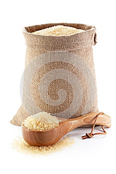 Rice in burlap sack and woodenware.