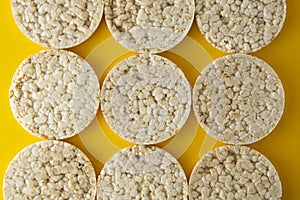 Rice cakes background, over yellow background. Top view. Food background. Dietary rice bread