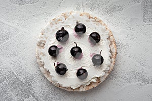 Rice cakes with cream cheese and black currant top view close up