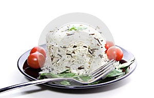 Rice with cherry tomatoes and greens on a black plate