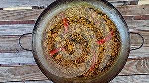 Rice cooked in a paella pan on a rustic wooden table