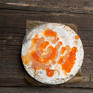 Rice crackers with smoked salmon spread on old wooden surface