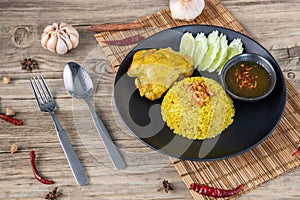 Rice with curried chicken. Delicious spicy chicken biryani in black bowl on wooden background, Indian or Pakistani ramzan food. Ho