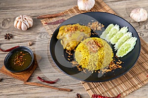 Rice with curried chicken. Delicious spicy chicken biryani in black bowl on wooden background, Indian or Pakistani ramzan food. Ho