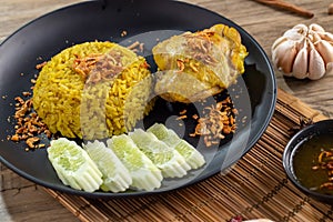 Rice with curried chicken. Delicious spicy chicken biryani in black bowl on wooden background, Indian or Pakistani ramzan food. Ho