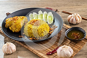 Rice with curried chicken. Delicious spicy chicken biryani in black bowl on wooden background, Indian or Pakistani ramzan food. Ho