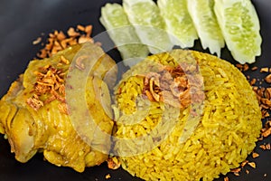 Rice with curried chicken. Delicious spicy chicken biryani in black bowl on wooden background, Indian or Pakistani ramzan food. Ho