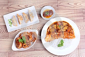 Rice with deep fried dolly fish in japanese yellow curry served with side dish of stuffing flour and onion ring on wood.