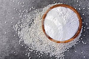 Rice flour in wooden bowl on gray background.