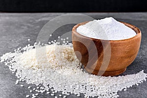 Rice flour in wooden bowl on gray background.