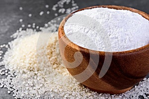 Rice flour in wooden bowl on gray background.