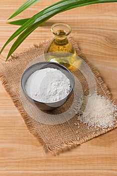 Rice flour in a wooden bowl, milk and oil with rice on the old w