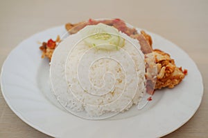 Rice with fried chicken and cucumber on white dish, stock photo