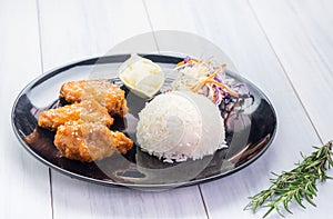 Rice,fried chicken wing and salad on tablecloth on white wood table in kitchen,food menu meal