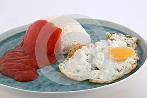 Rice with fried eggs tomato sauce and fried banana