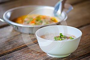 Rice gruel and panned egg on wooden table photo