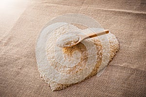 Rice laid out in a heart shape on sackcloth with wooden spoon