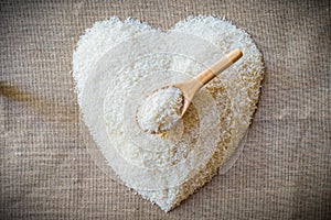 Rice laid out in a heart shape on sackcloth with wooden spoon