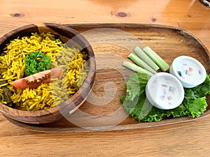 Rice lamb biryani pilaf with lamb meat and vegetables cucumber along with yoghurt