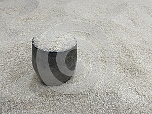 Rice measuring tool with a pile of rice in the background