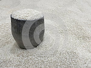 Rice measuring tool with a pile of rice in the background