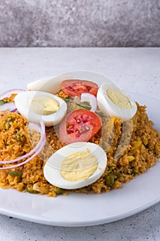 Rice noodle dish or string hoppers biryani with boiled eggs, tomatoes, onions and curry leaves, closeup view