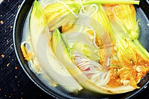 Rice noodle soup with pumpkin flowers