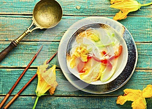 Rice noodle soup with pumpkin flowers,wooden background