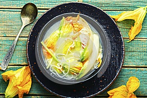 Rice noodle soup with pumpkin flowers,wooden background