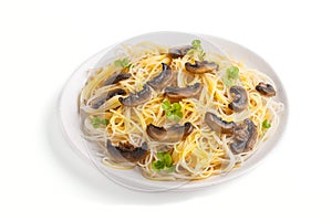 Rice noodles with champignons mushrooms, egg sauce and oregano on white ceramic plate isolated on white background. side view