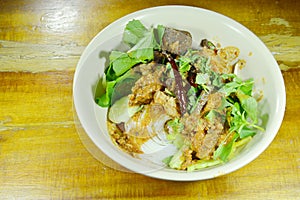 Rice noodles dressing spicy minced pork and bone red cotton tree sauce with vegetable on bowl photo