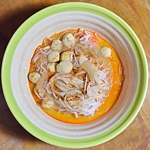 Rice noodles in fish curry sauce with vegetables.