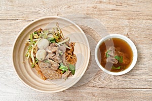 Rice noodles topping braised pork and ball on bowl with bone in brown herb soup cup photo