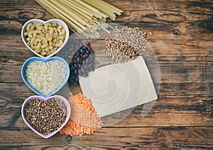 Rice, pasta, buckwheat, beans and wheat, grocery products on  wooden table