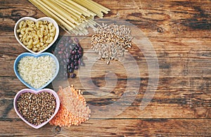Rice pasta buckwheat beans wheat grocery products on wooden table