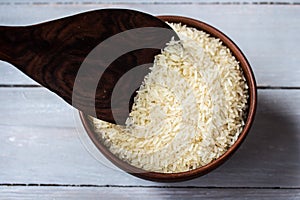 Rice in the plate and wooden spoon