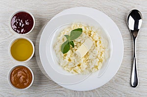 Rice porridge with butter, mint in plate, jam, honey, spoon