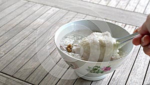 Rice porridge with pork meat in a bowl. Closeup.