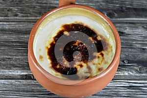 Rice pudding pottery casserole baked in the oven, rice, corn flour, sugar, water or milk and other ingredients such as cinnamon,