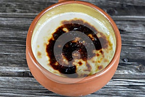 Rice pudding pottery casserole baked in the oven, rice, corn flour, sugar, water or milk and other ingredients such as cinnamon,