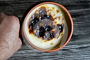 Rice pudding pottery casserole baked in the oven, rice, corn flour, sugar, water or milk and other ingredients such as cinnamon,