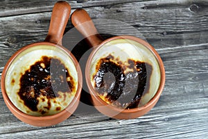 Rice pudding pottery casserole baked in the oven, rice, corn flour, sugar, water or milk and other ingredients such as cinnamon,