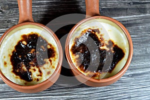 Rice pudding pottery casserole baked in the oven, rice, corn flour, sugar, water or milk and other ingredients such as cinnamon,